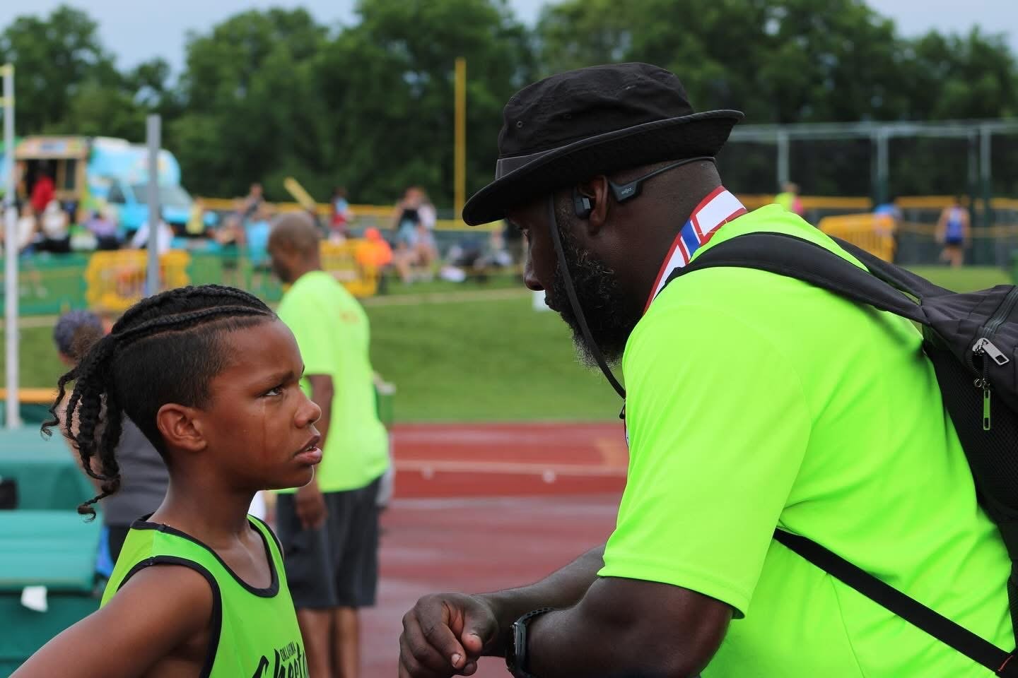A Cheetah coach giving direct instruction to a young athlete at a meet