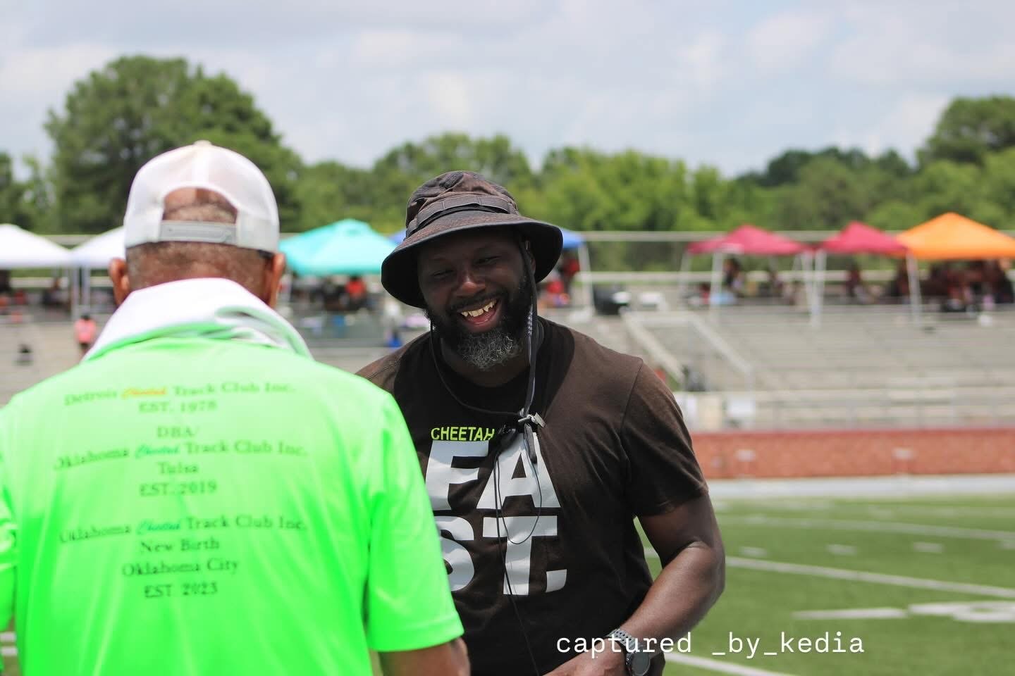 A Cheetah coach in a shirt showing the program history: Detroit 1978, Tulsa 2019, Oklahoma City 2023