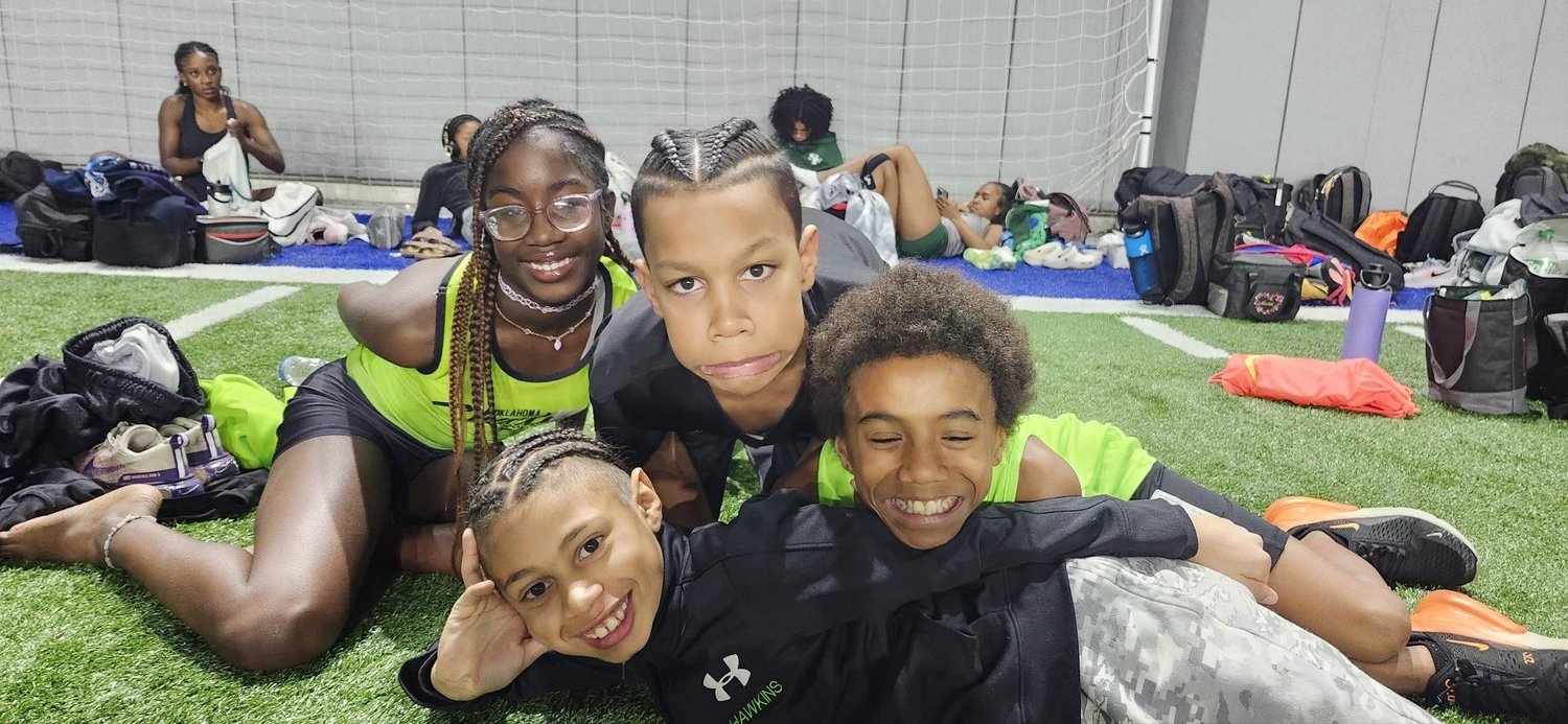 A group of young Cheetah athletes in their gear, smiling together at practice