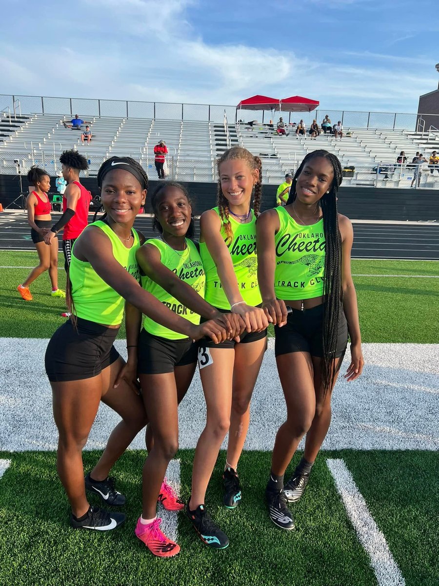 A group of Cheetah girl athletes locked arm-in-arm before a relay