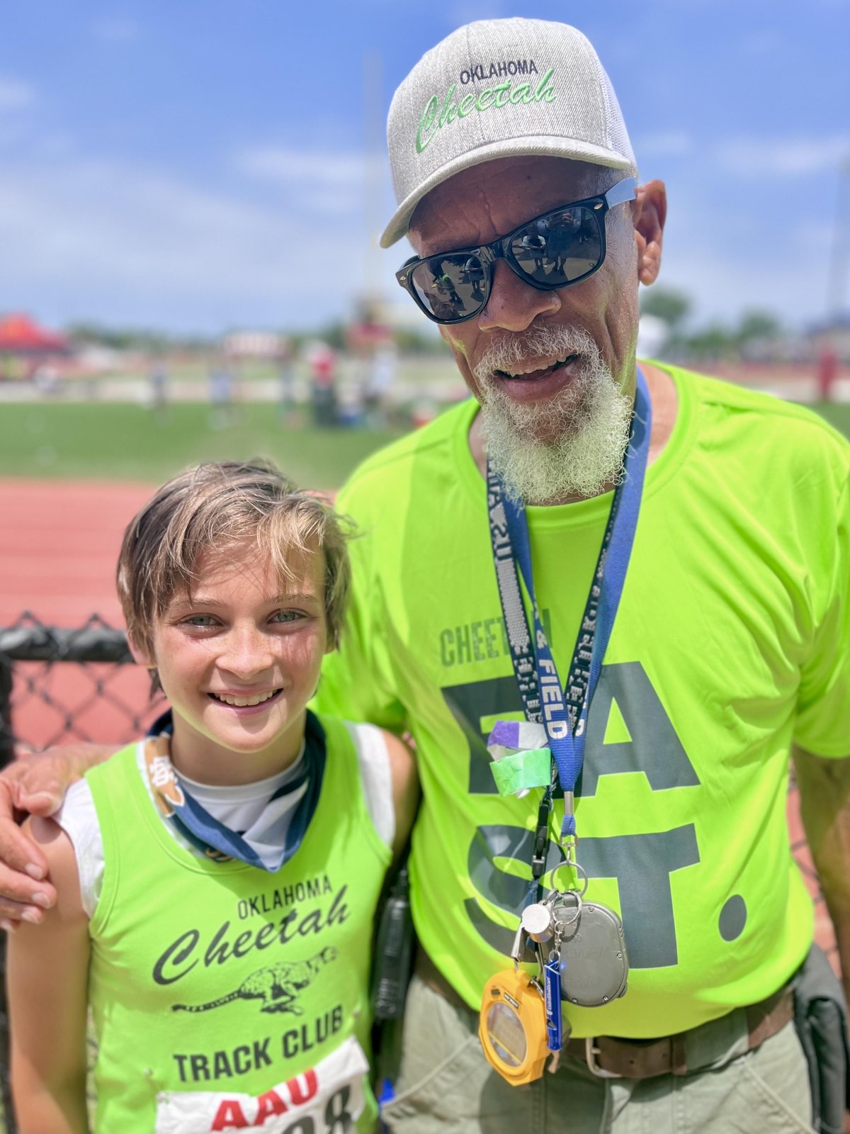 Coach Harry Weaver with a young Oklahoma Cheetah athlete at a meet